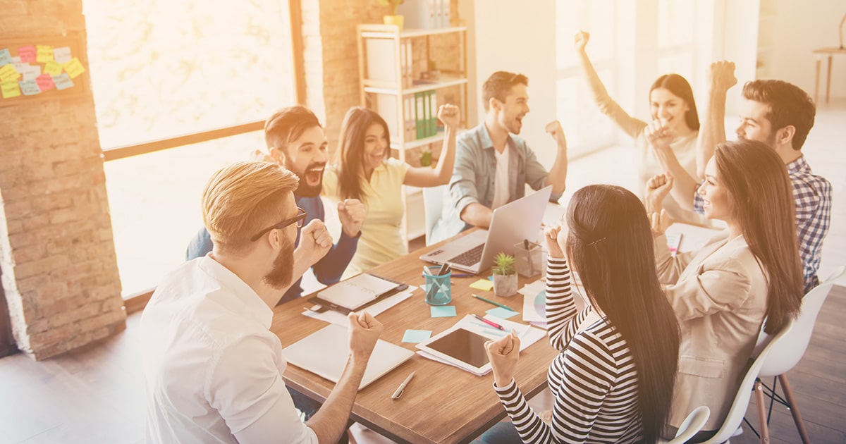 Group of people in work office sitting and cheering.