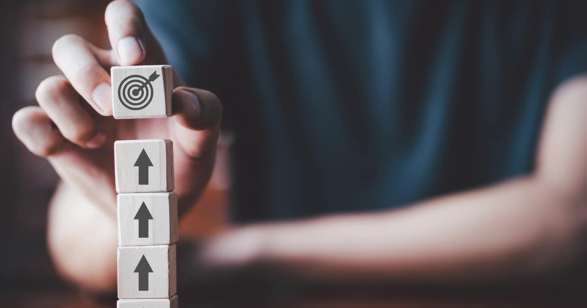 Hand with stacked blocks with arrows point upwards