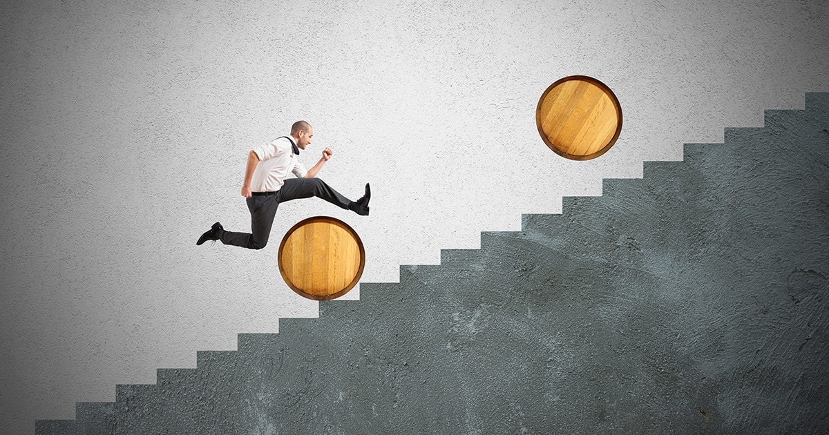 Man running up stairs jumping over a barrel.